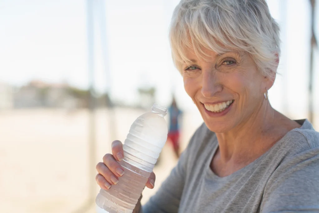 senior woman with water bottle for daily hydration
