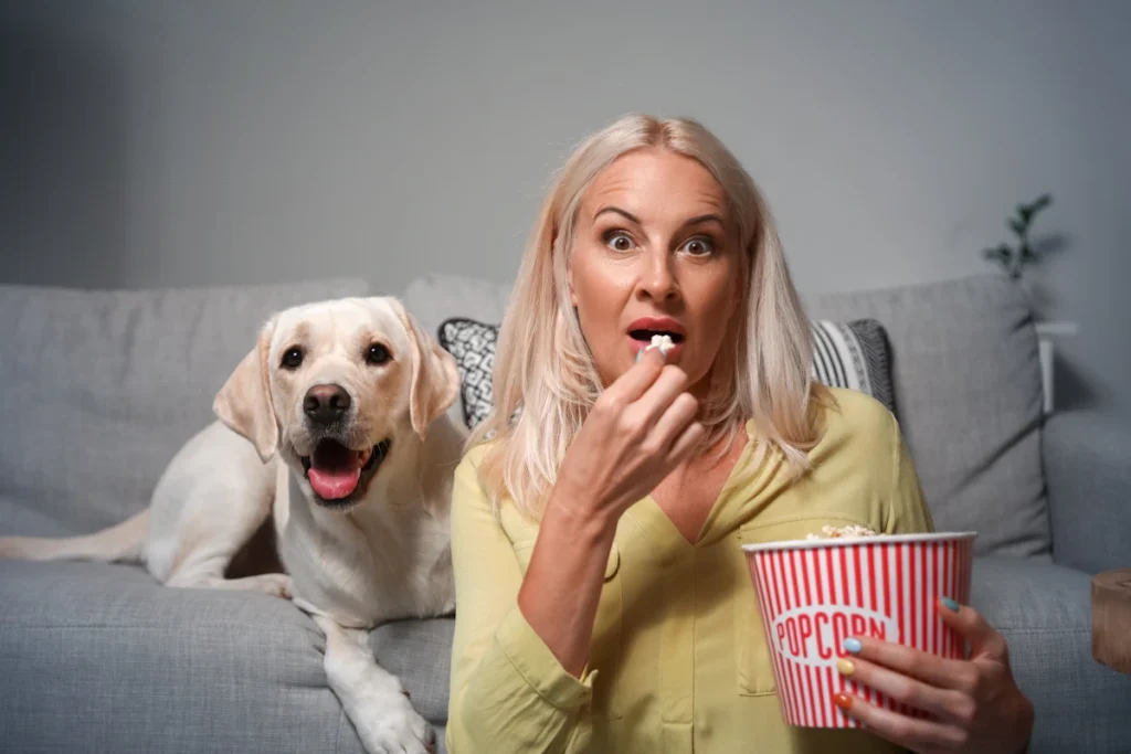 woman and dog watching scary movie